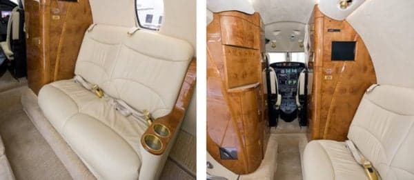 Interior of the aircraft featuring cream-colored leather seats and wood paneling.