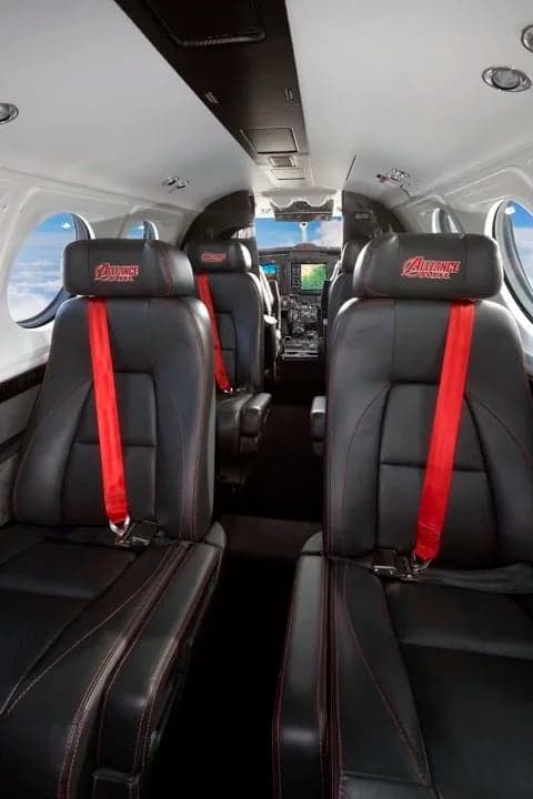 The interior of a King Air aircraft with leather seats and a view towards the cockpit.