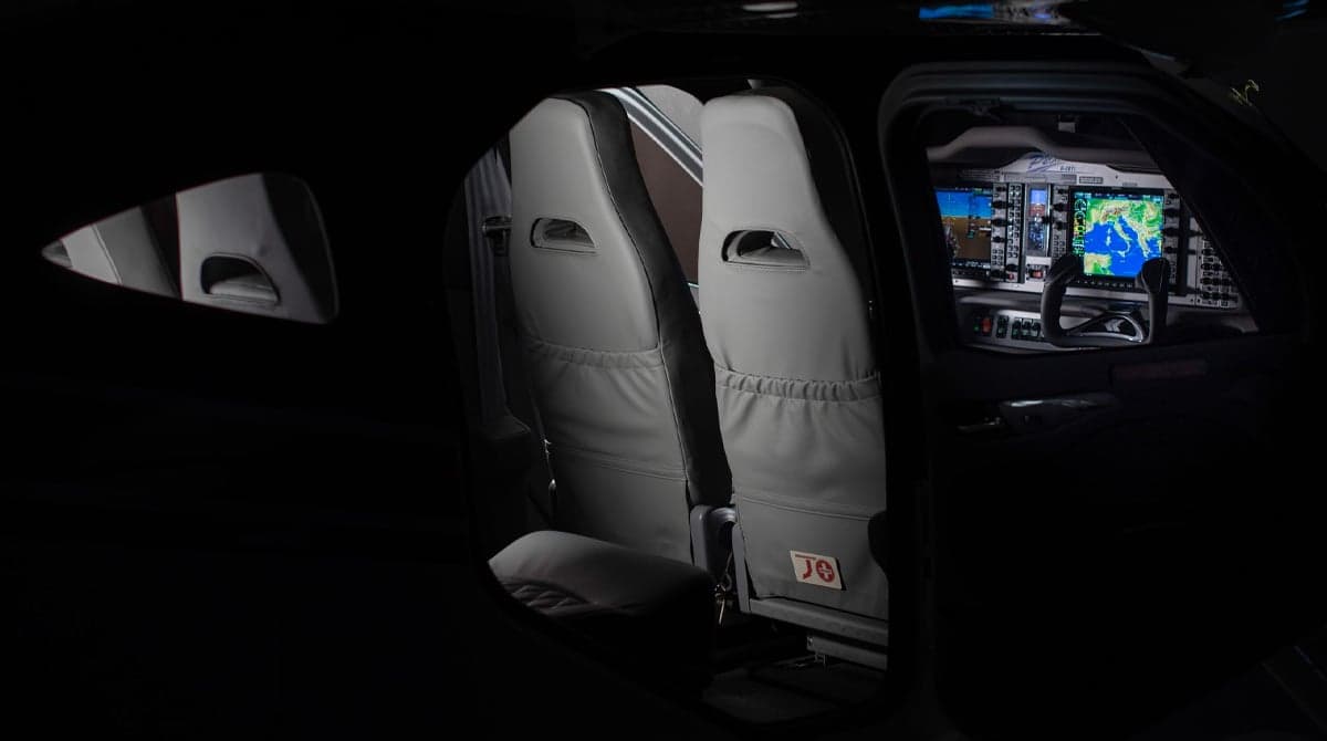 View of the aircraft's interior with gray leather seats and cockpit.