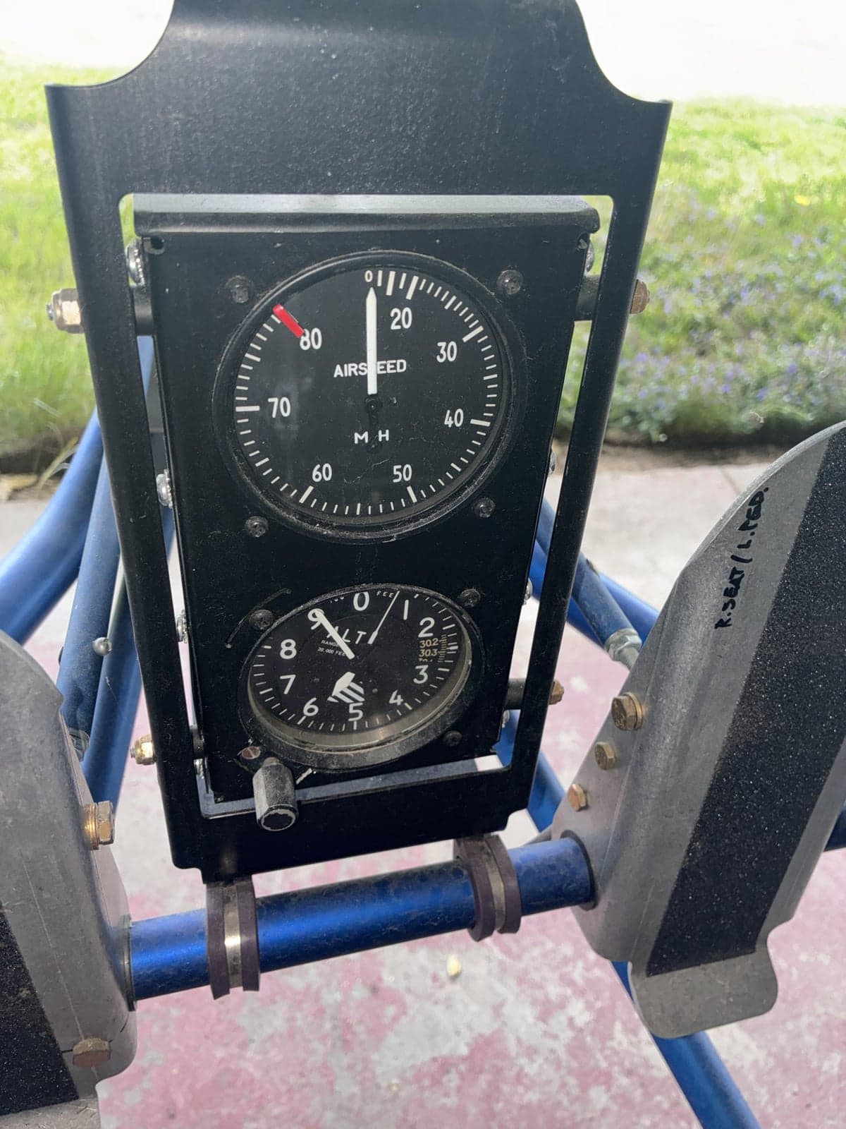 Close-up of the airspeed indicator and altimeter gauges on the instrument panel of the ultralight aircraft.