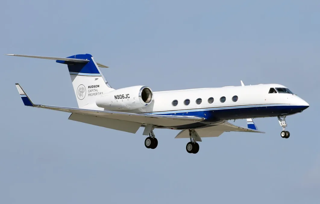A Gulfstream G550 aircraft with blue and white livery is landing.