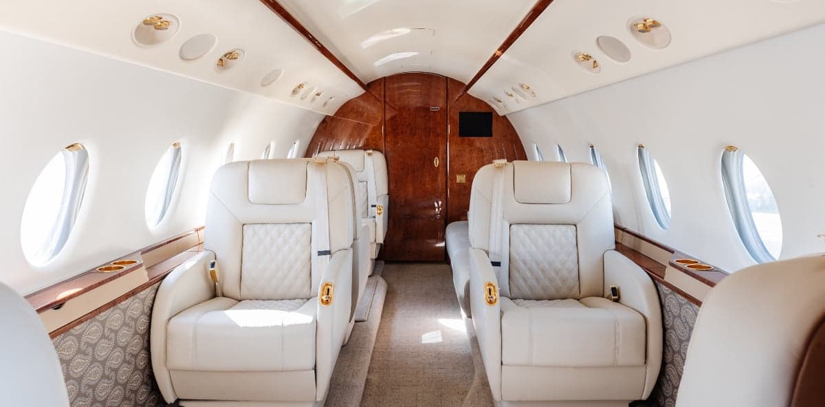 Interior view of the aircraft cabin with white leather seats.