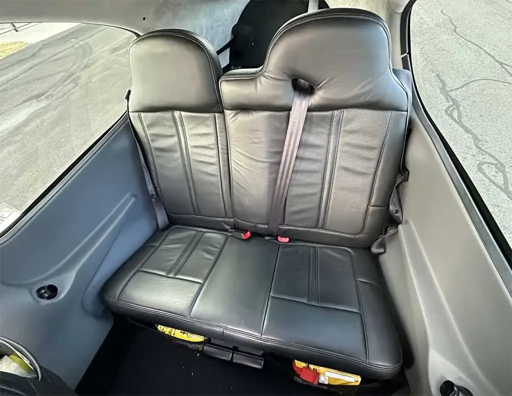 The black leather rear seats of a Cirrus SR22 aircraft cabin.