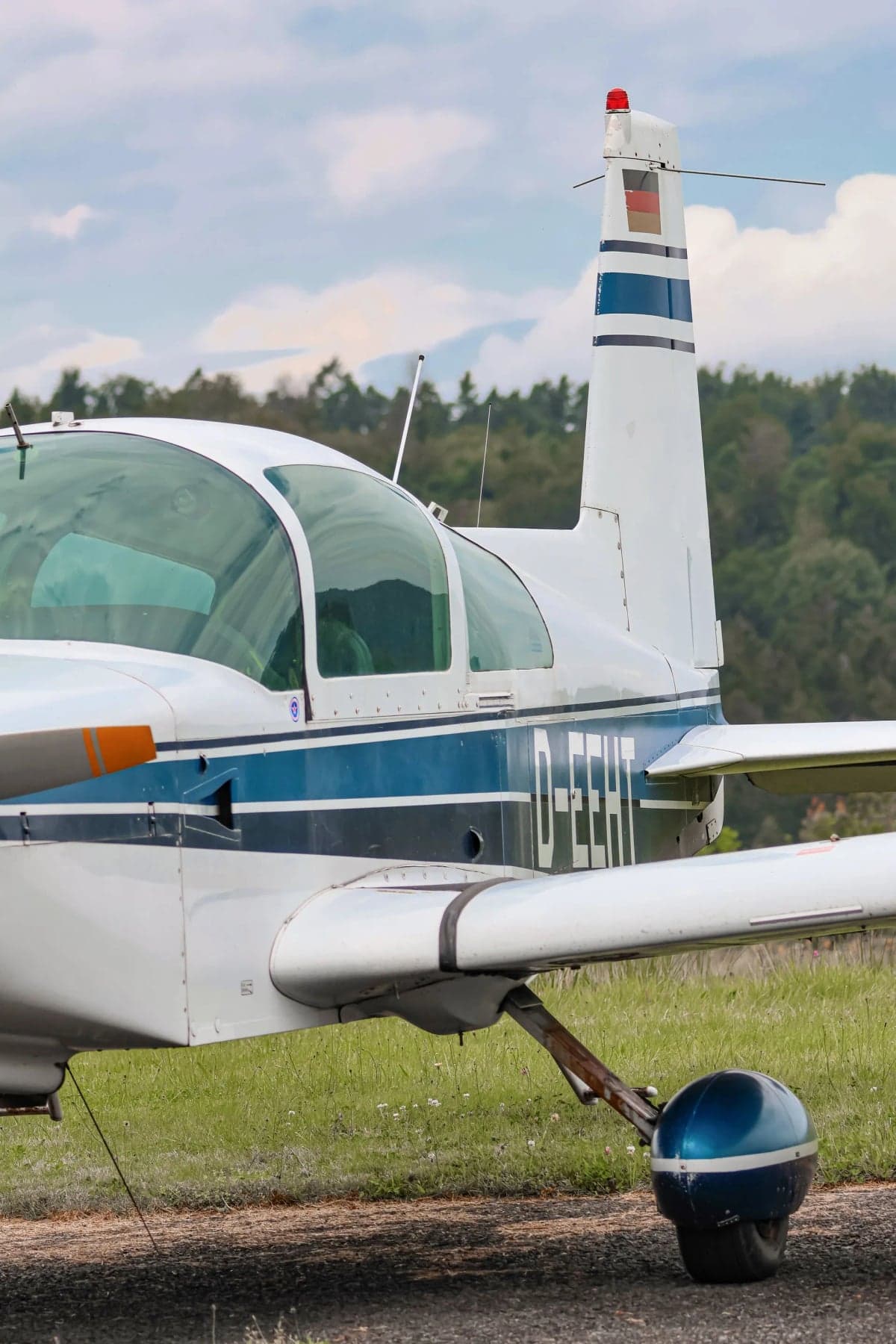 Close-up of the tail of a white and blue aircraft with the registration D-EEHT.