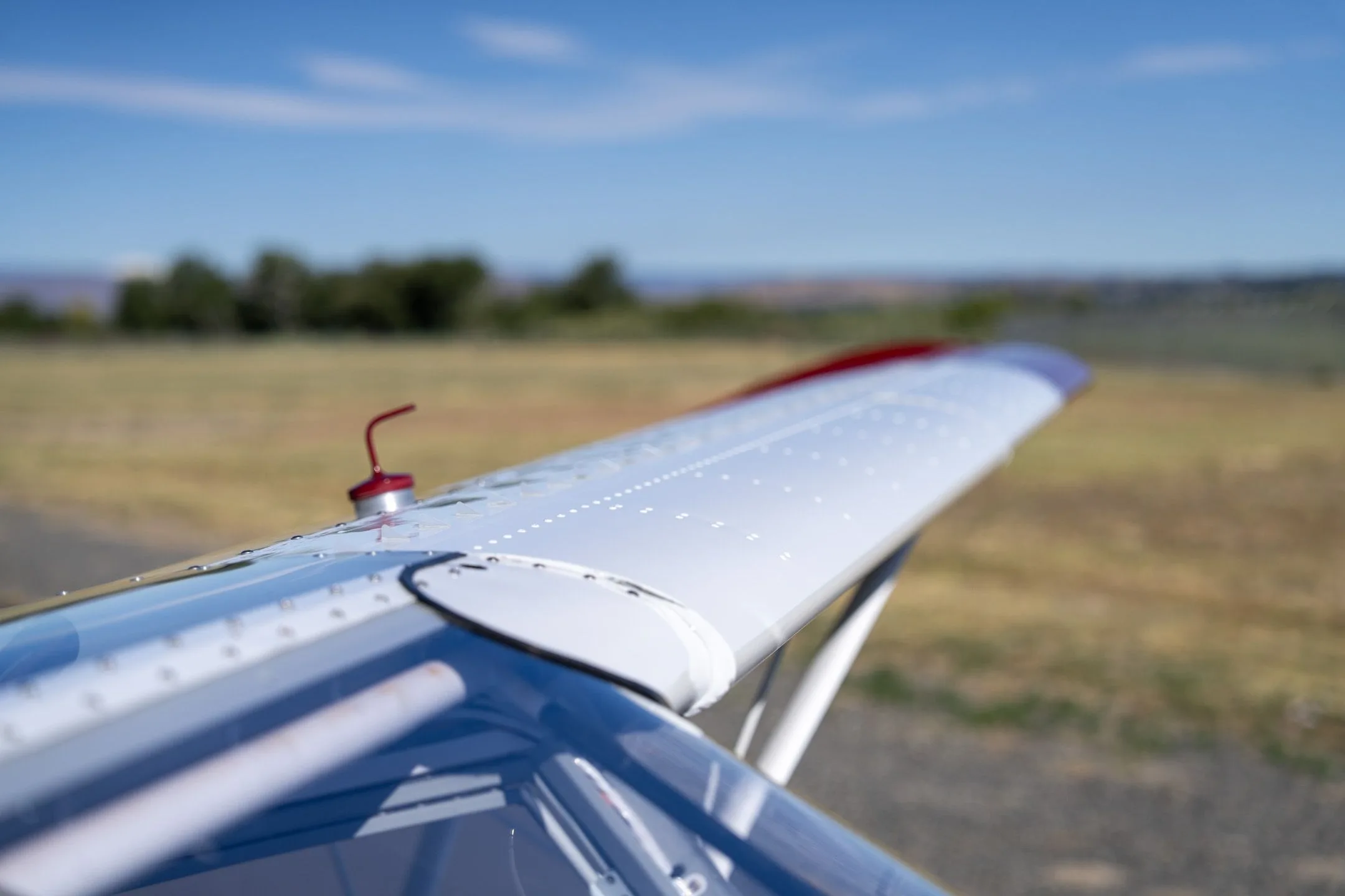 Close-up of the white wing surface of a Just Aircraft SuperSTOL with a fuel cap.