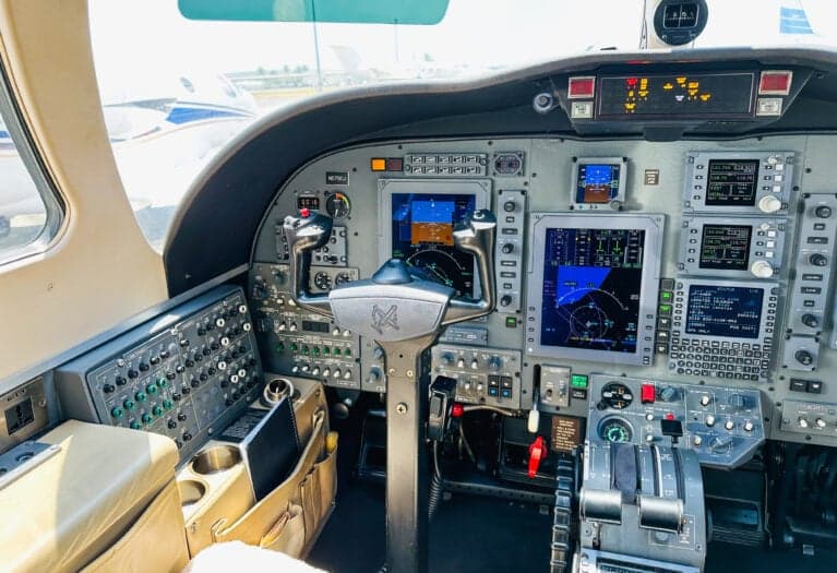 A view of the Cessna Citation CJ3 cockpit from the left seat, showing the instrument panel, yoke, and center console.