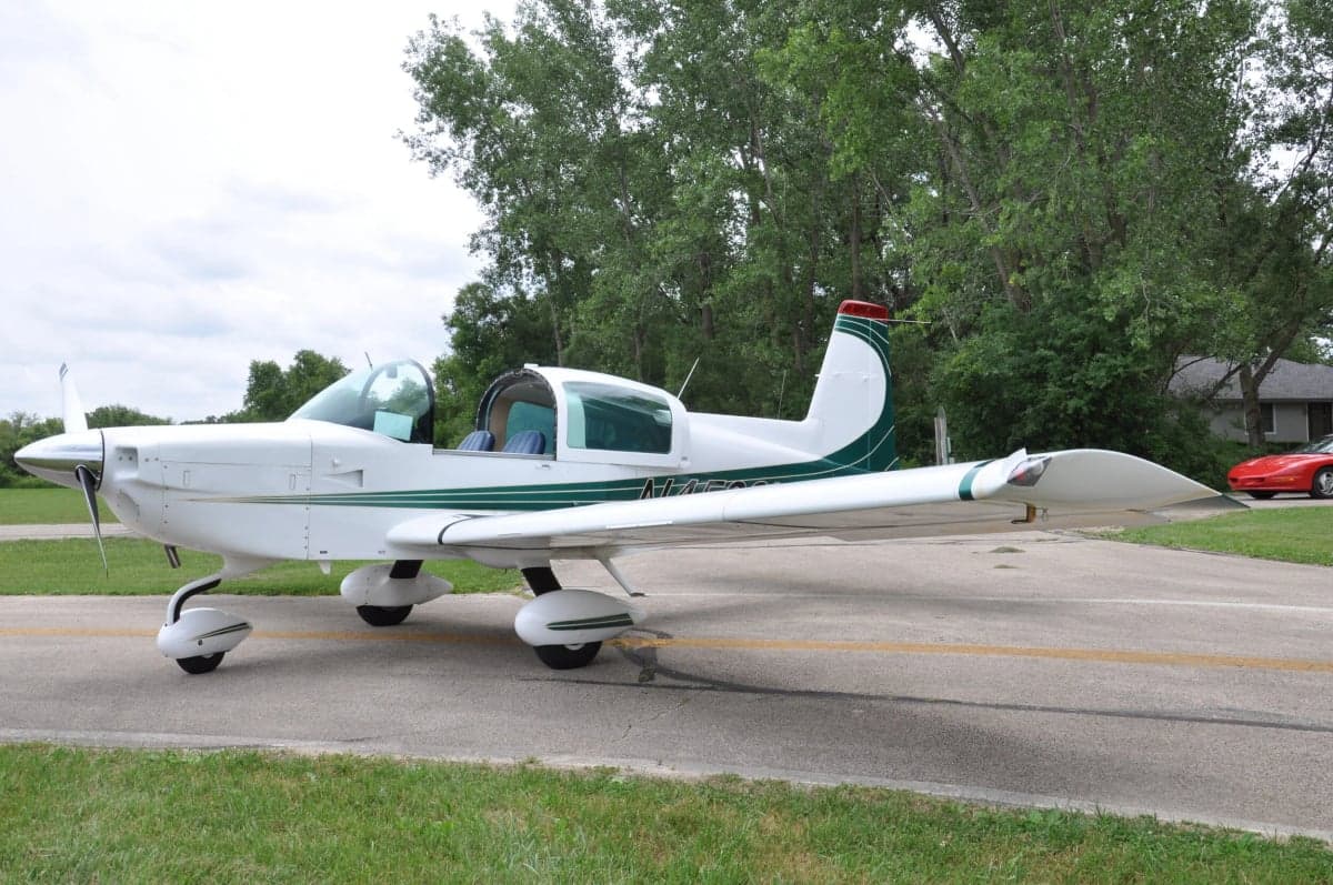 Side view of a white and green aircraft on the tarmac.