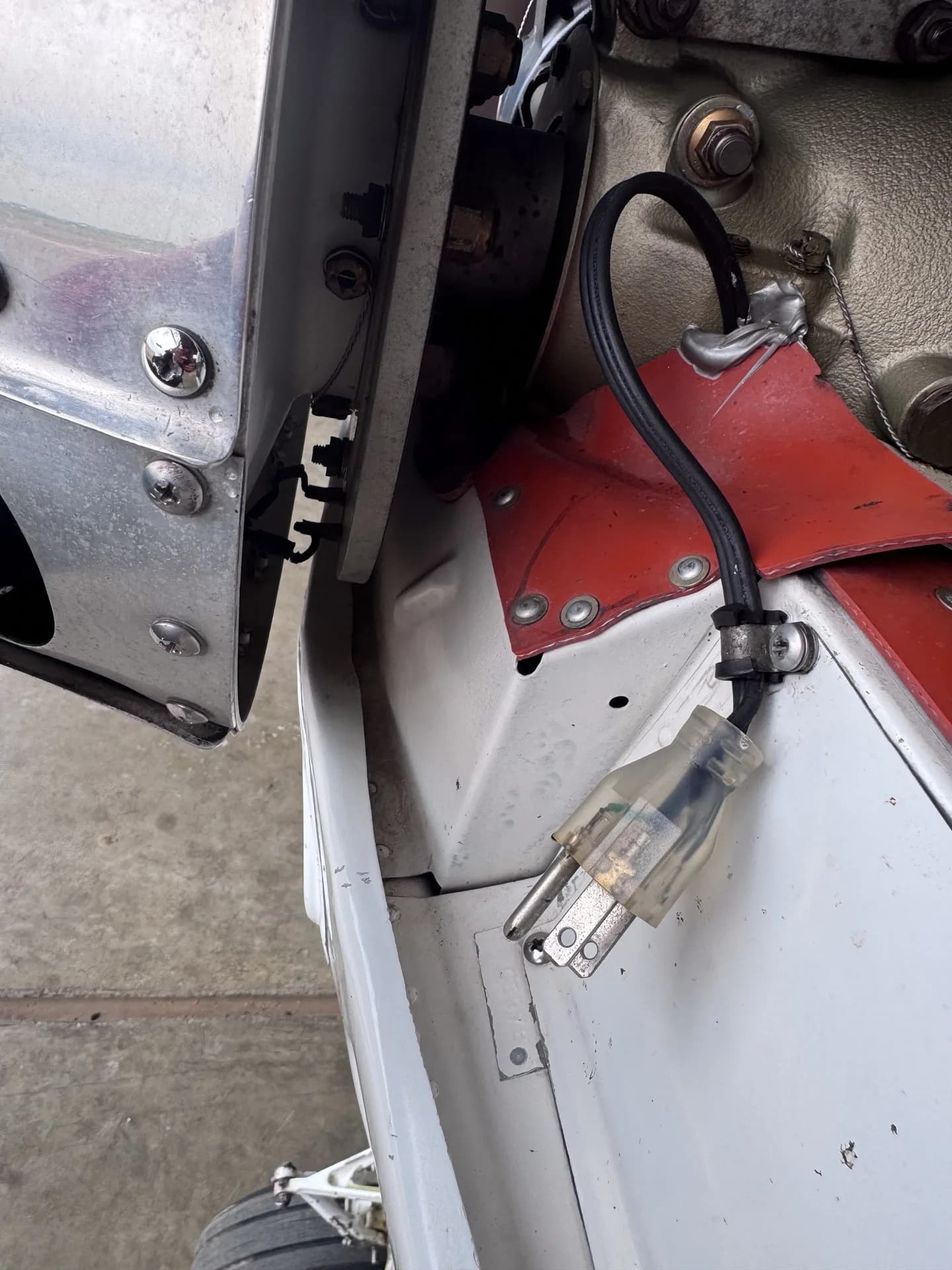 A clear electrical plug connected to the aircraft's engine compartment.