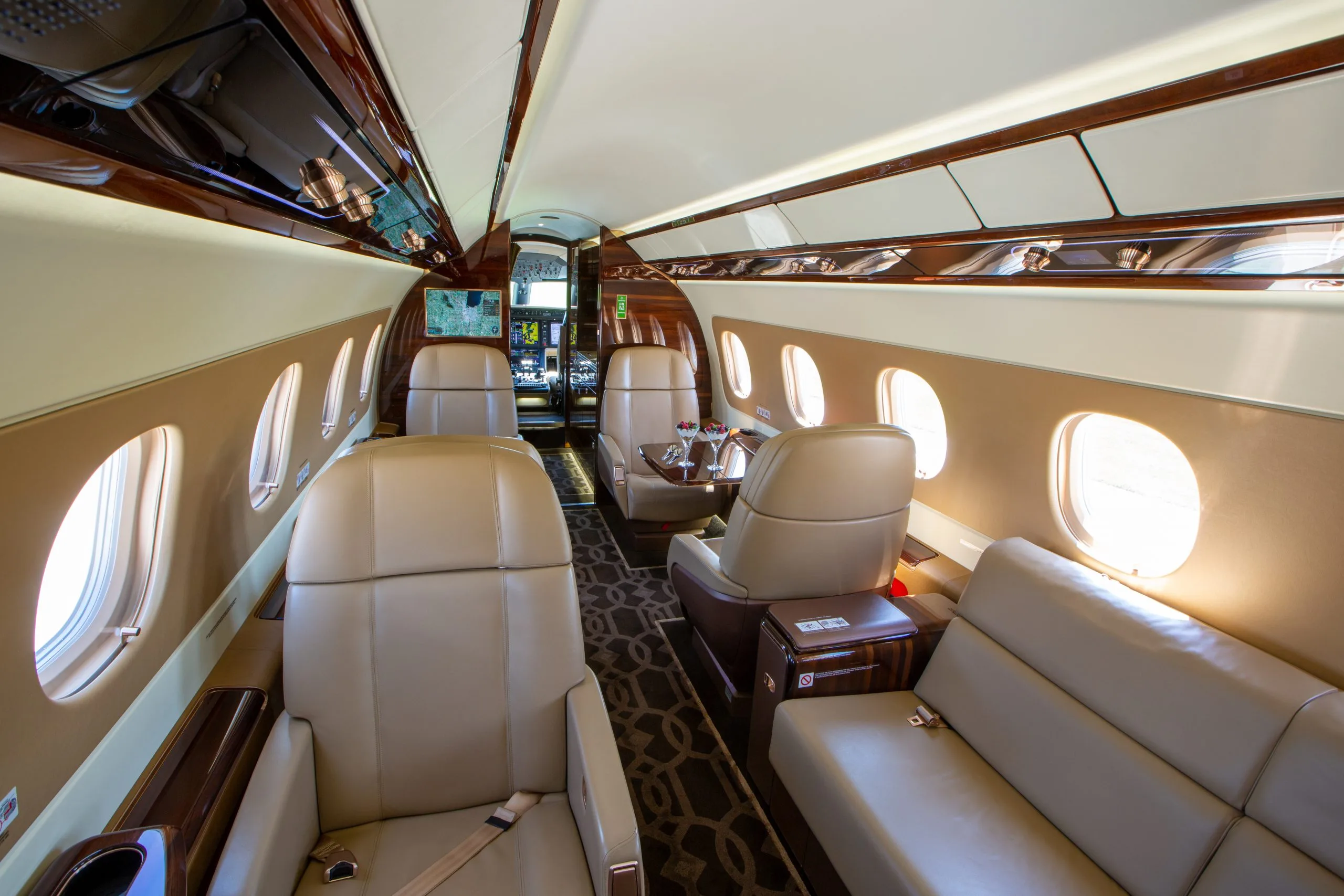 The interior of an Embraer Phenom 300E with a view of the cockpit and cabin seats.