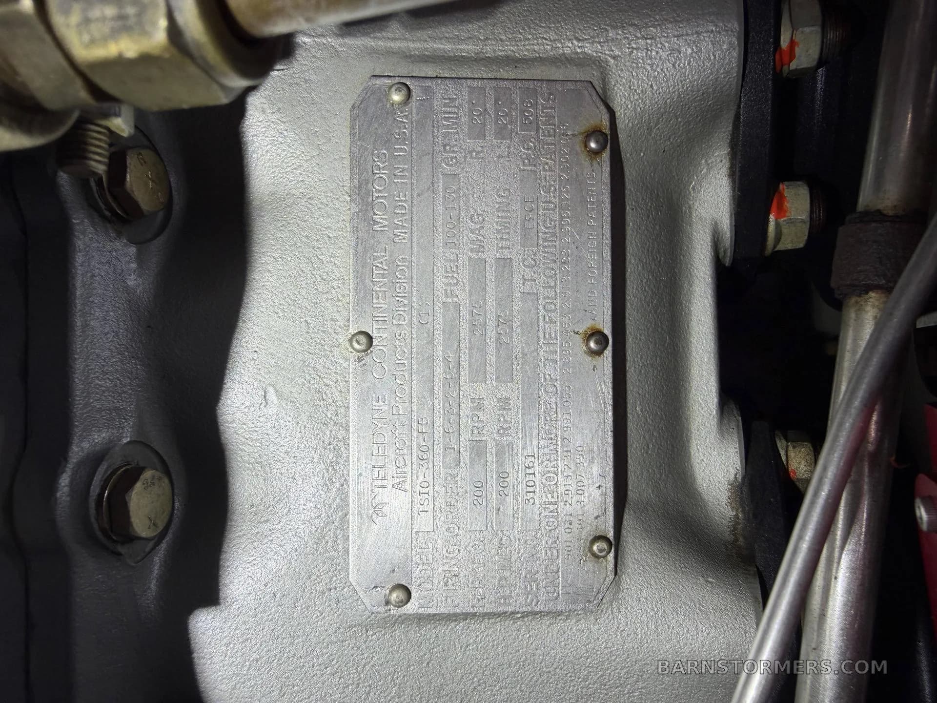 A close-up of the Teledyne Continental Motors data plate on an aircraft engine, showing model and serial numbers.