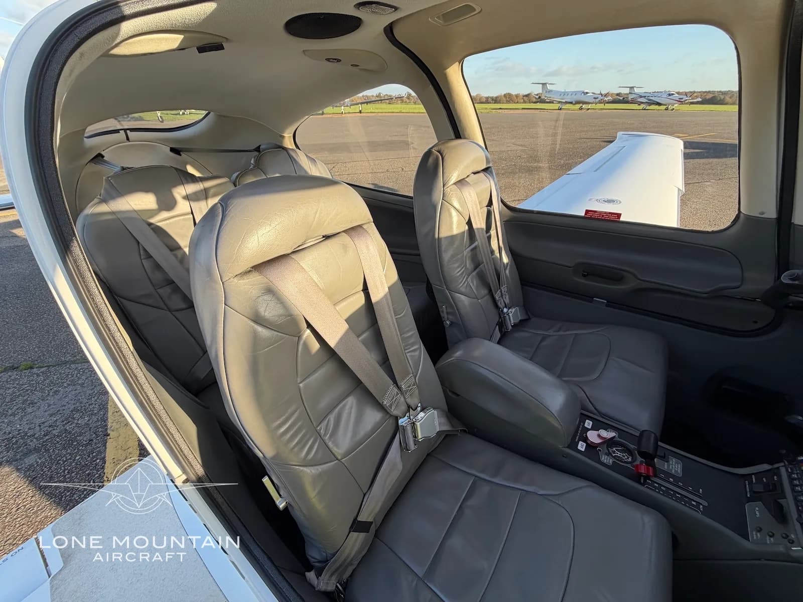 A side view of the grey leather seats in the cabin of the Cirrus SR22 aircraft, looking towards the front.
