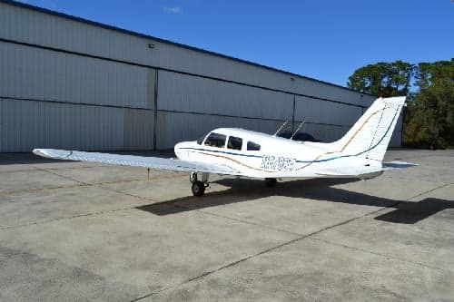 Side view of a white and silver Piper PA-28-181 Archer II aircraft, N6789T, parked on a concrete surface.