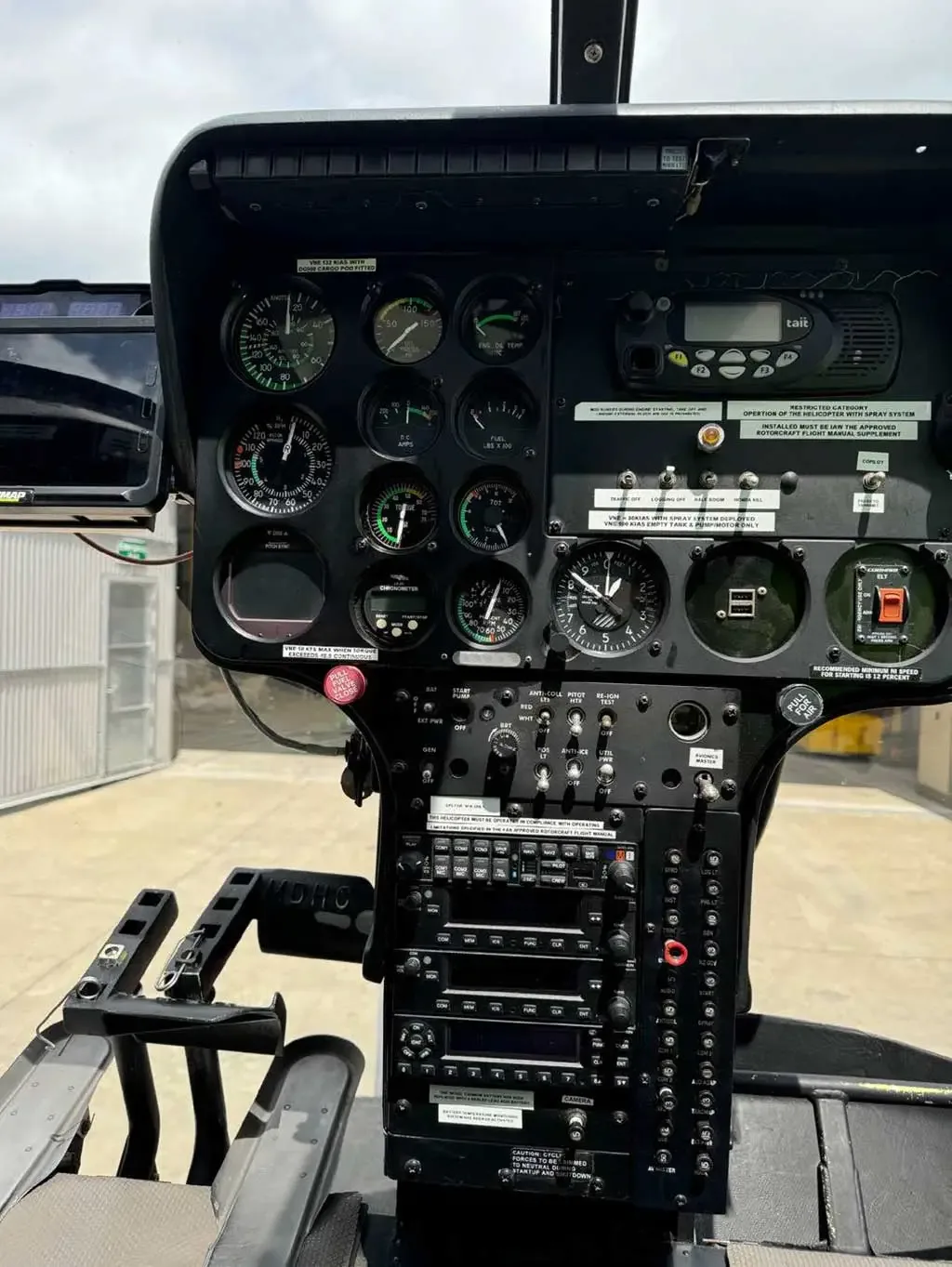 A clear view of the MD 530 helicopter's instrument panel, showing gauges, radios, and controls.