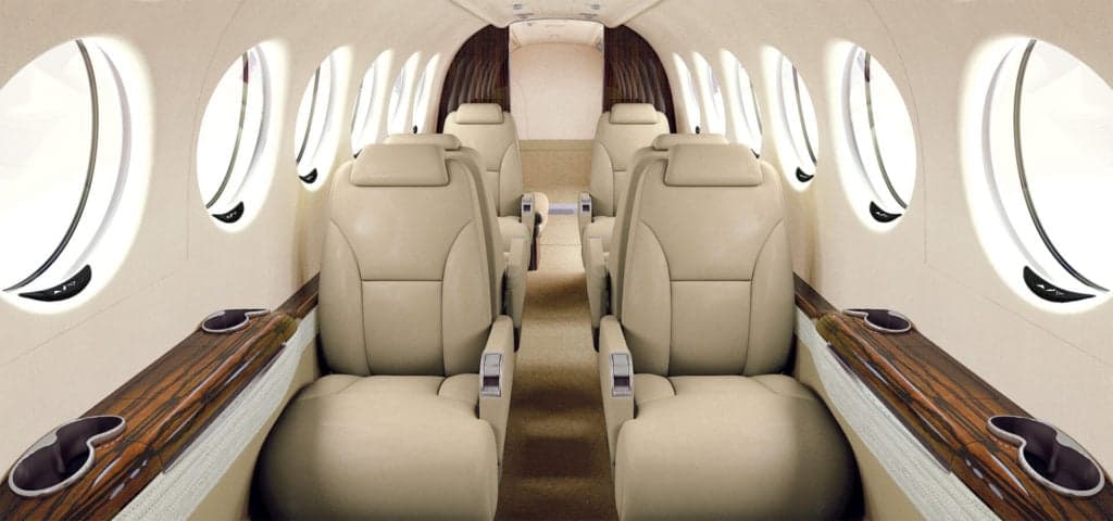 The interior of a King Air aircraft with leather seats and wood trim.