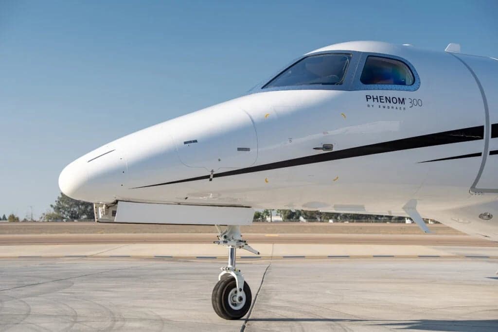 Close-up of the nose of a Phenom 300 aircraft.