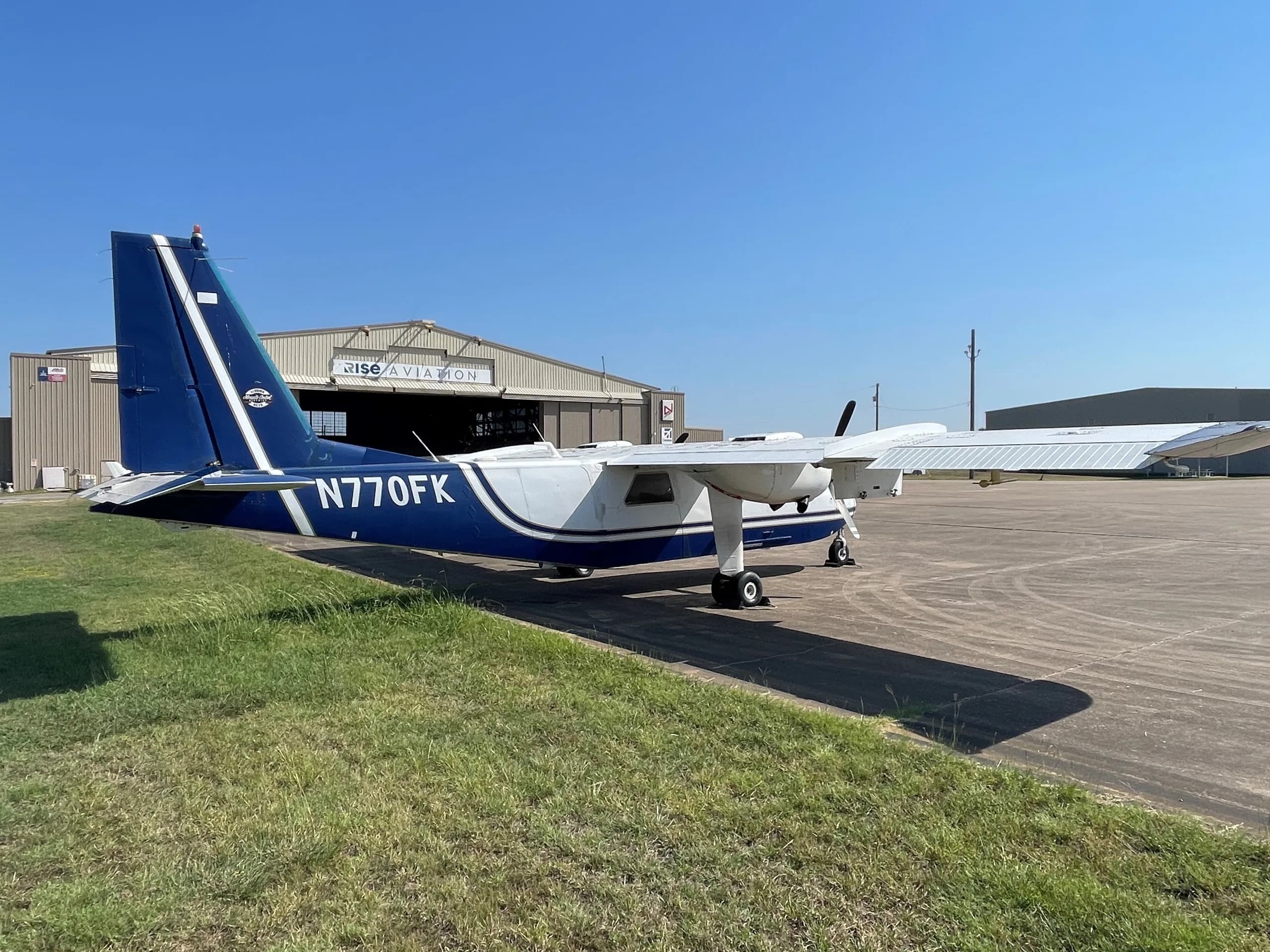 Aircraft N770FK parked in front of a hangar.