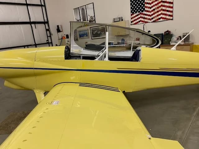 Side view of the yellow N639TB aircraft with the canopy open.