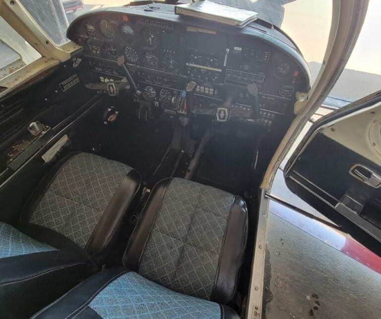 View of the cockpit and front seats of an aircraft, showing the instrument panel and controls.