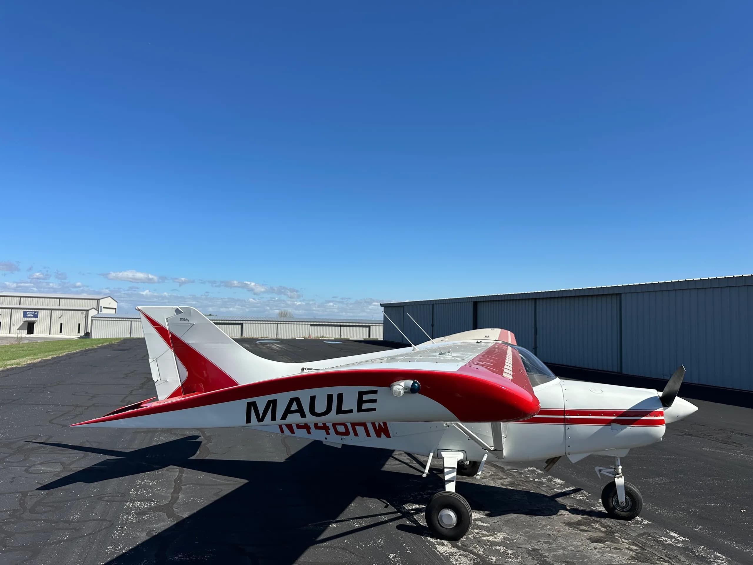 A Maute aircraft with red and white paint scheme is parked on the tarmac.