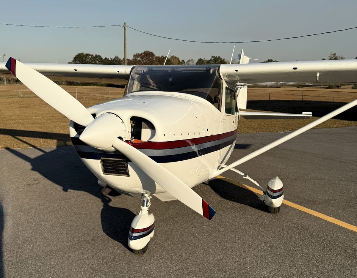Close-up of the front of the Cessna 210 Centurion N71002, showing the propeller and engine cowling.