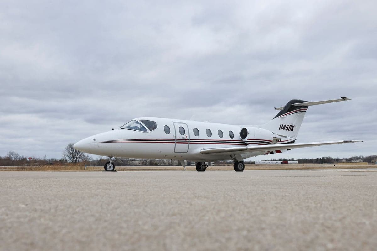 A Hawker jet with a white and red paint scheme parked on the tarmac.