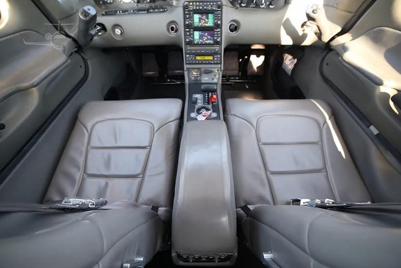 Front seats of a Cirrus SR22 aircraft, showing the leather upholstery and center console.