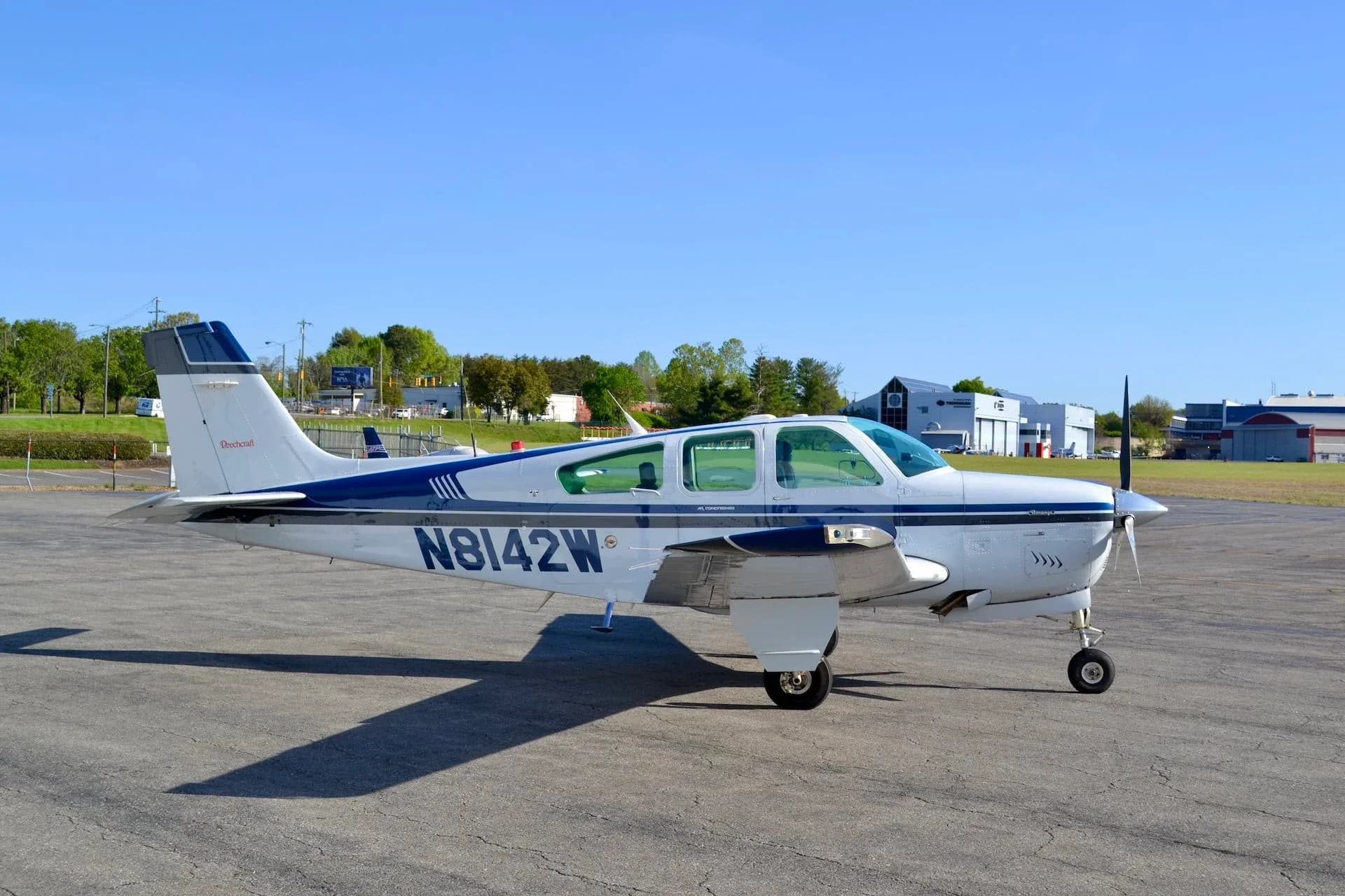 Beechcraft Bonanza N8142W parked on the tarmac with a blue and white paint scheme.