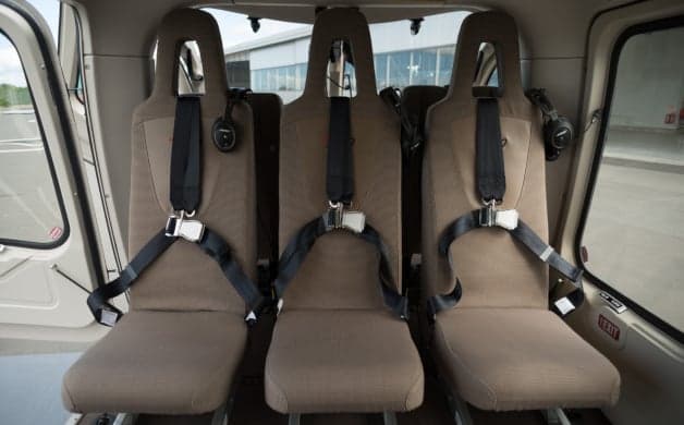 The interior of a helicopter with three seats.