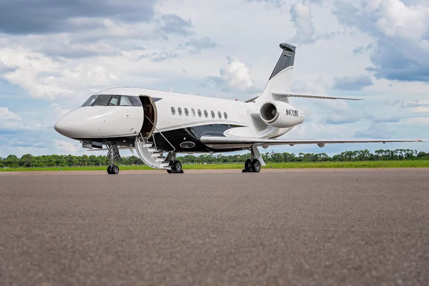 The aircraft N470MK is parked on the tarmac with the door open.
