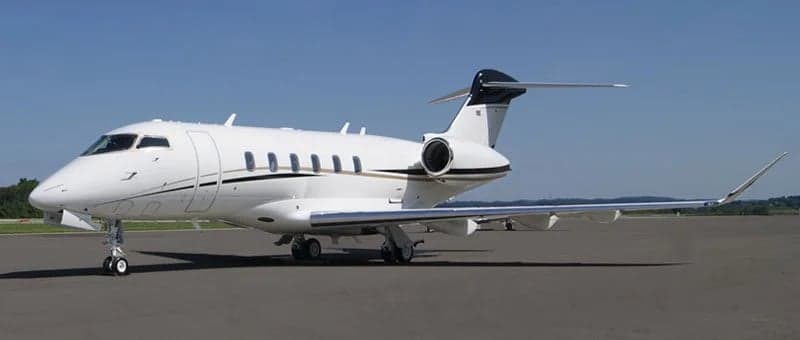 A white and gold Bombardier Challenger parked on the tarmac.
