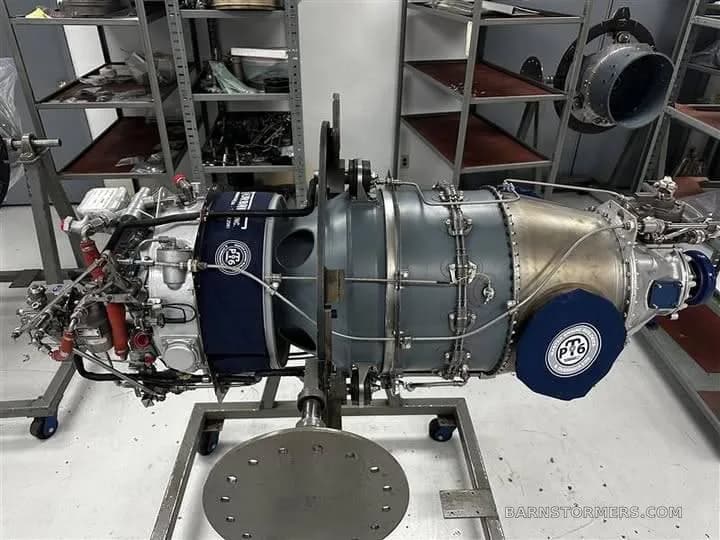 A Pratt & Whitney PT6 turboprop aircraft engine on a stand in a maintenance facility.