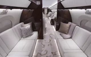 A view of the aircraft's interior with white sofas and a patterned carpet.