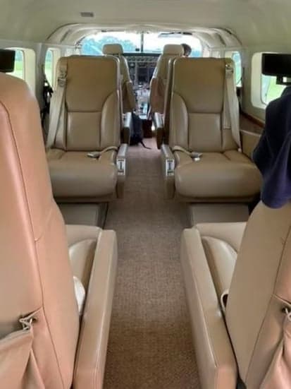 The interior of the aircraft features tan leather seats.