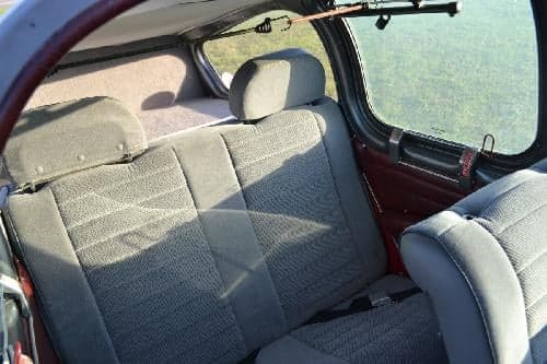 The interior of the aircraft shows the rear seats and window.