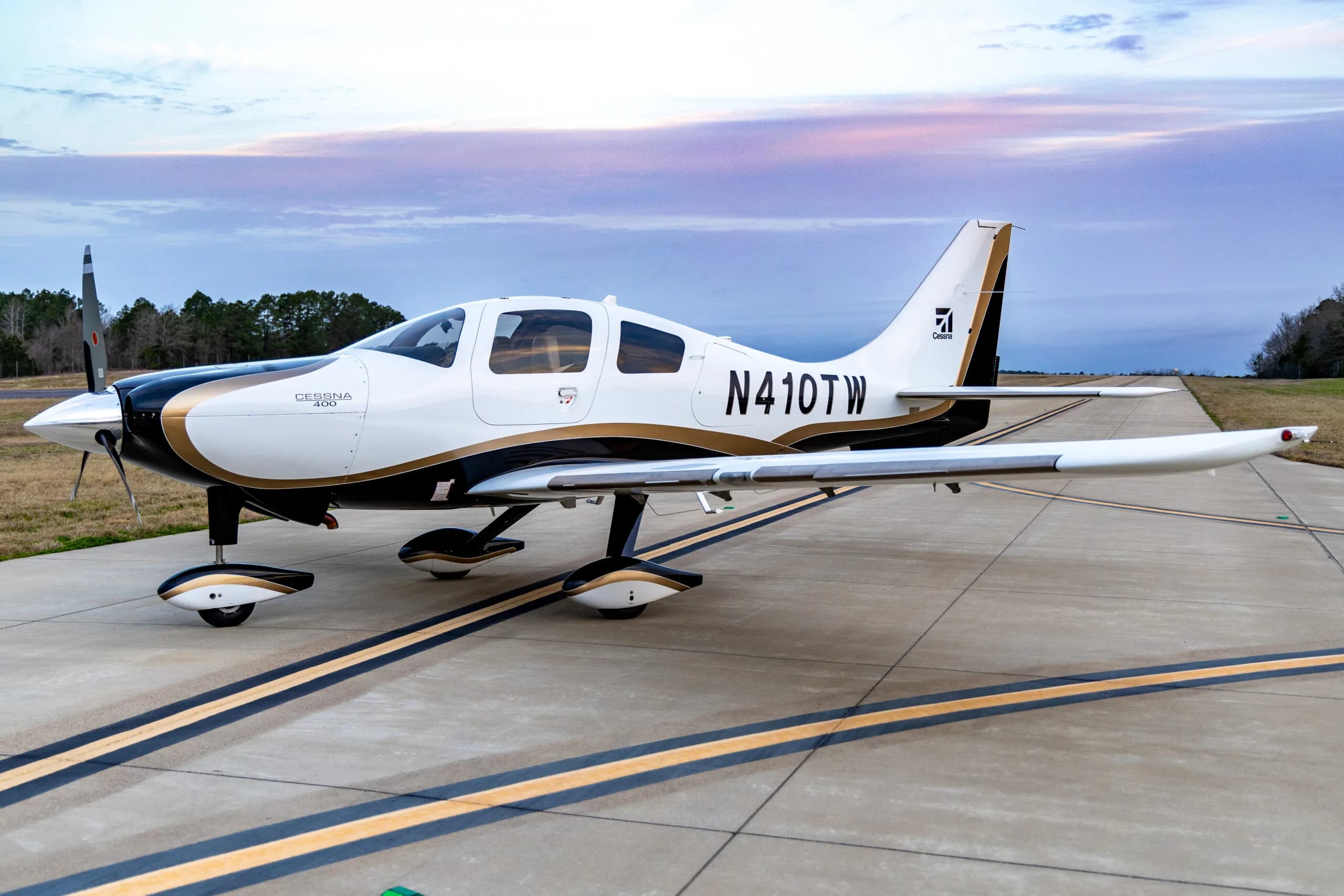 Cessna 400, registration N410TW, parked on the tarmac with a white and gold paint scheme.