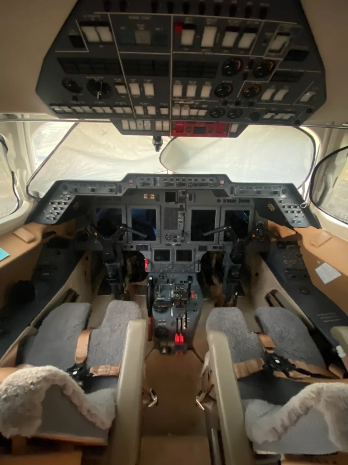 View of the cockpit instrument panel and seats of the aircraft.