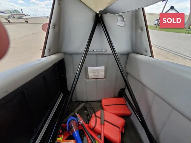 View of the aircraft's baggage area with red emergency supplies.