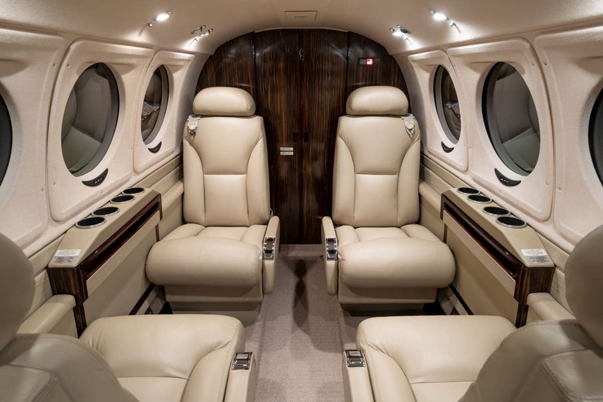 Interior view of the aircraft cabin with leather seats and wood trim.