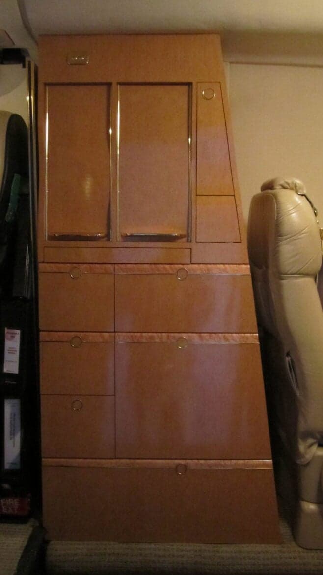 A cabinet and seat inside the aircraft cabin.