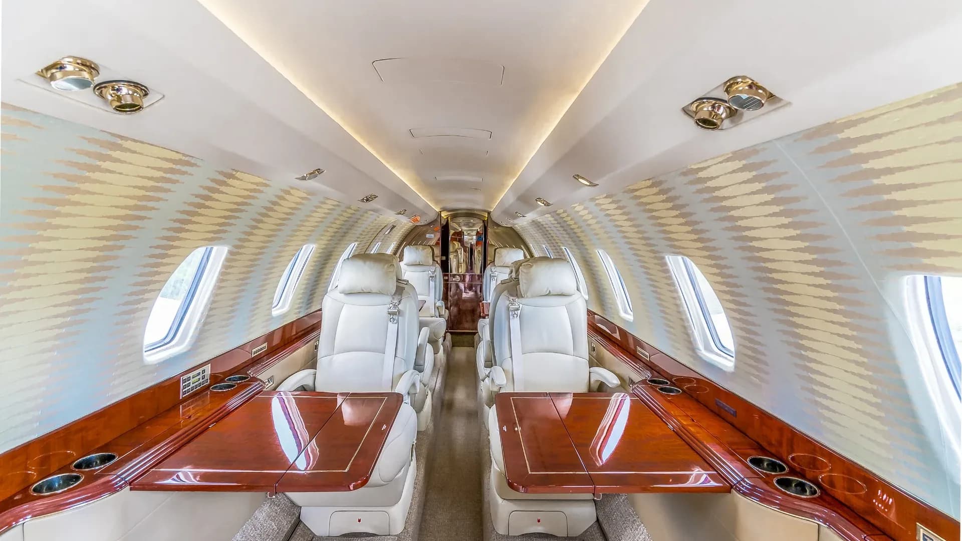 View of the aircraft's interior cabin with leather seats and wood accents.