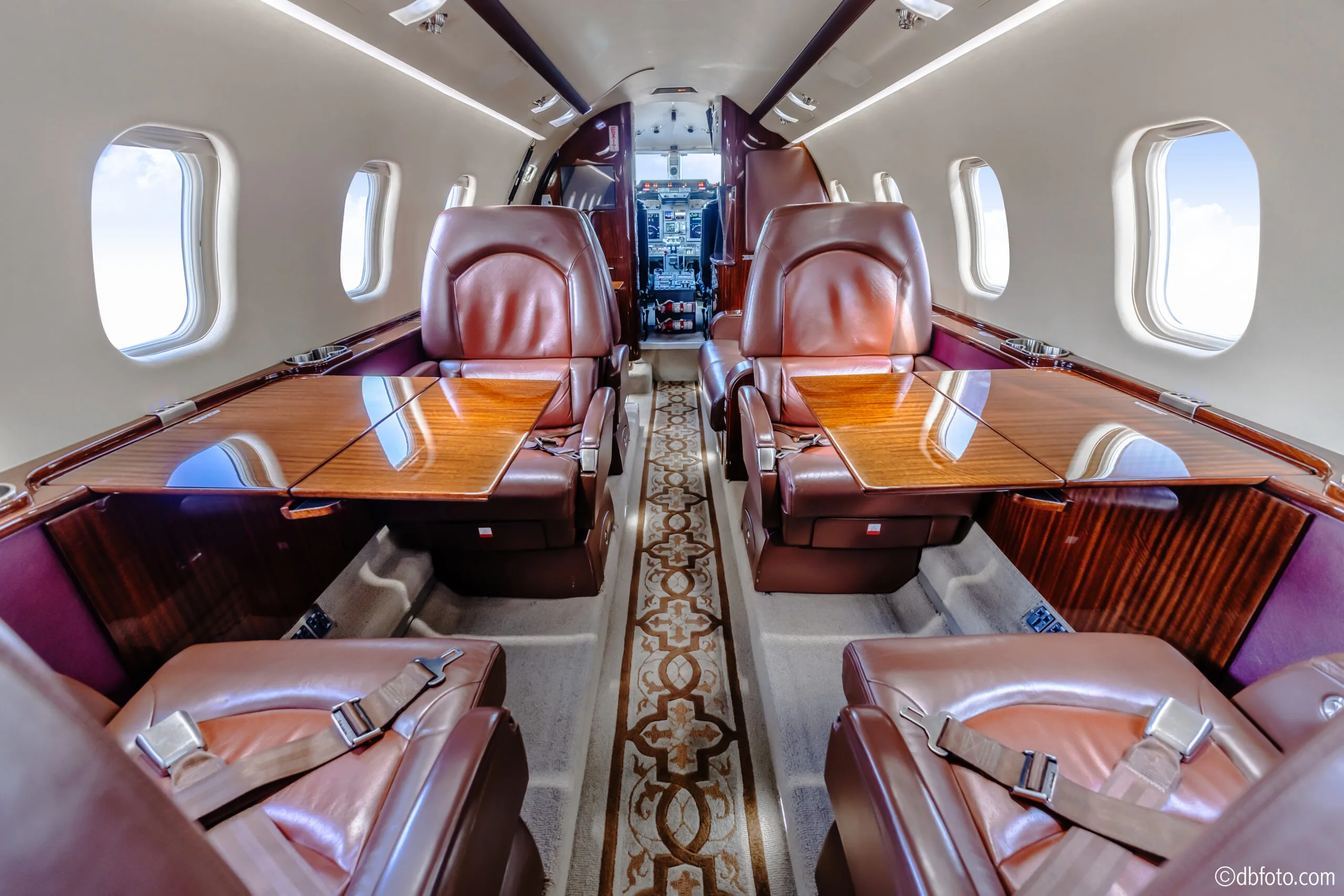 View of the Learjet 45XR cabin with leather seats and tables.