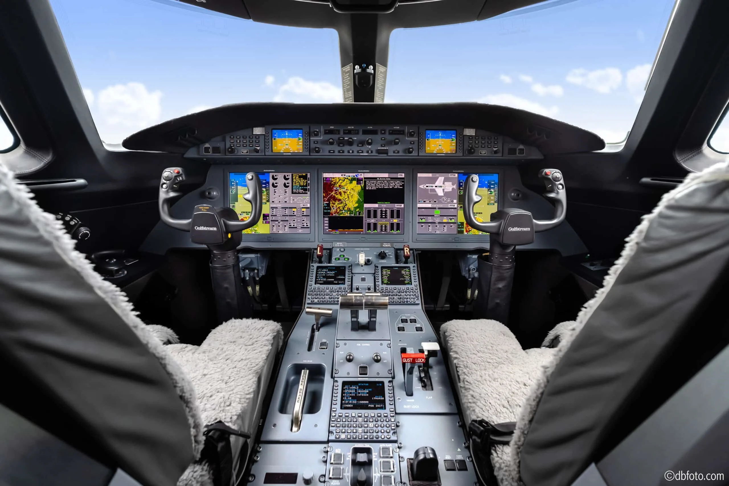 The modern glass cockpit of a Gulfstream G550 (or similar large business jet) with multiple display screens.