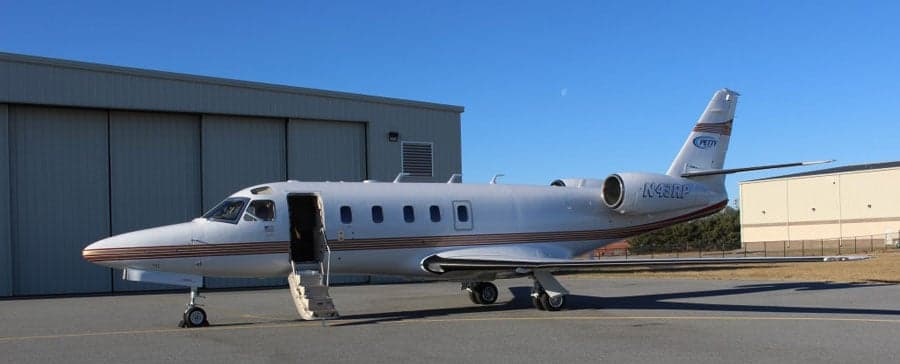 A Cessna Citation jet with an open door parked on the tarmac.