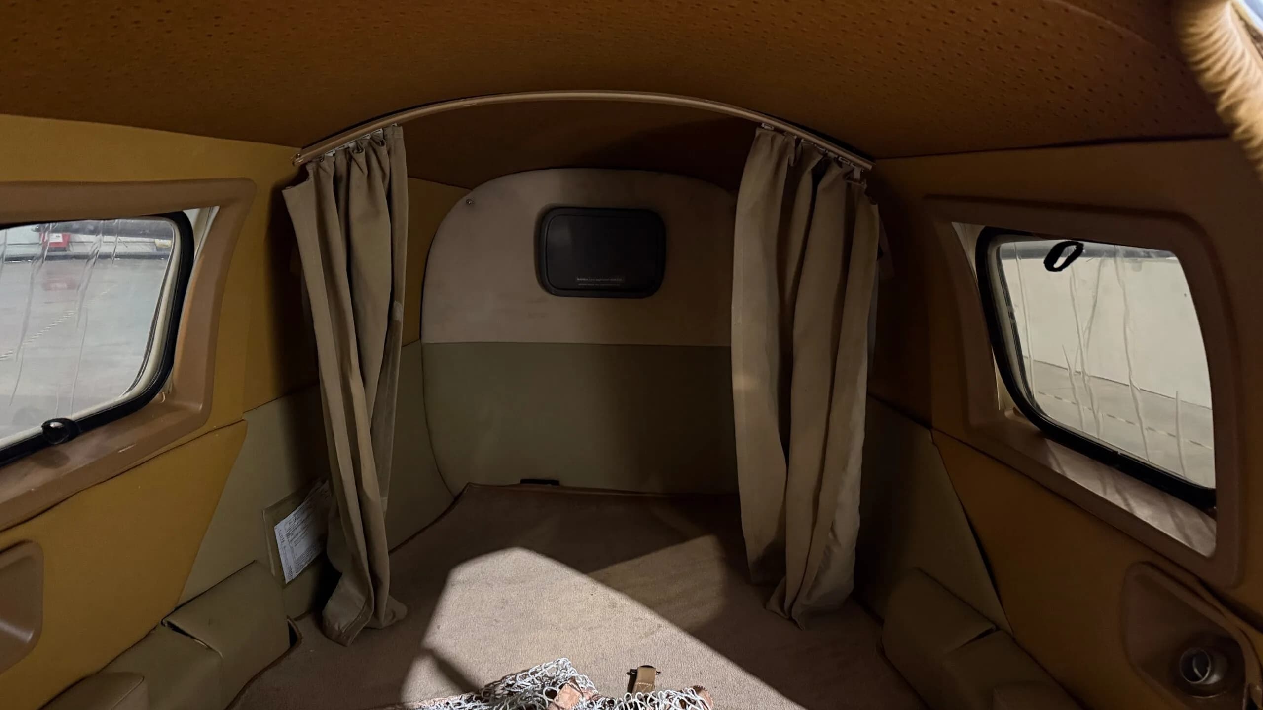 View of the aircraft interior with curtains and windows.