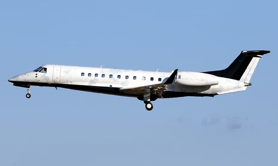 Embraer Legacy 600 in flight with a white and black paint scheme.
