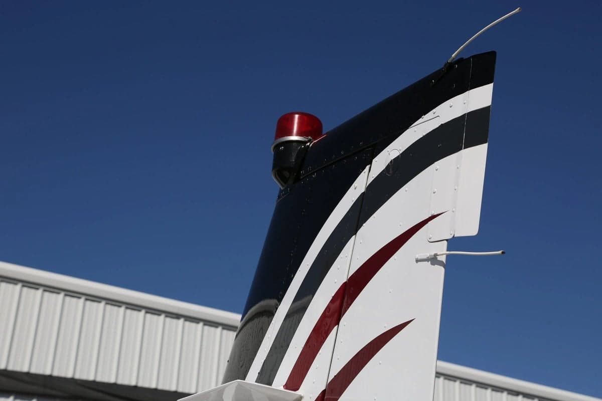 Close-up of the tail of a Beechcraft Bonanza showing the paint scheme.