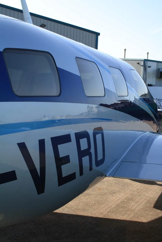 A close-up view of the blue and silver fuselage of the Piper M600SLS aircraft (G-VERO) showing its registration.