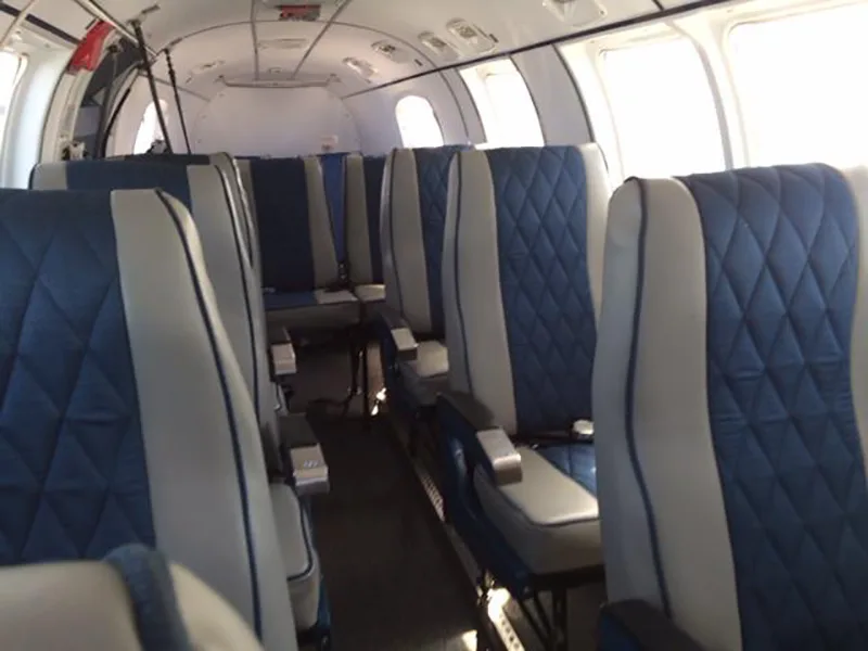 Interior view of aircraft cabin with blue and gray seats.