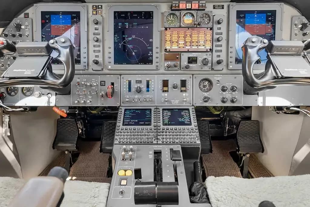 A detailed view of the private jet's modern cockpit instrument panel with multiple digital displays and controls.