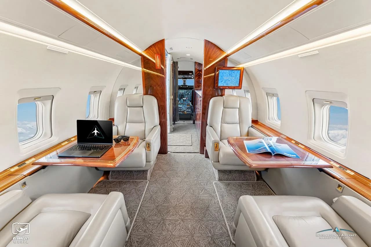 Interior view of the aircraft cabin with leather seats and wood trim.